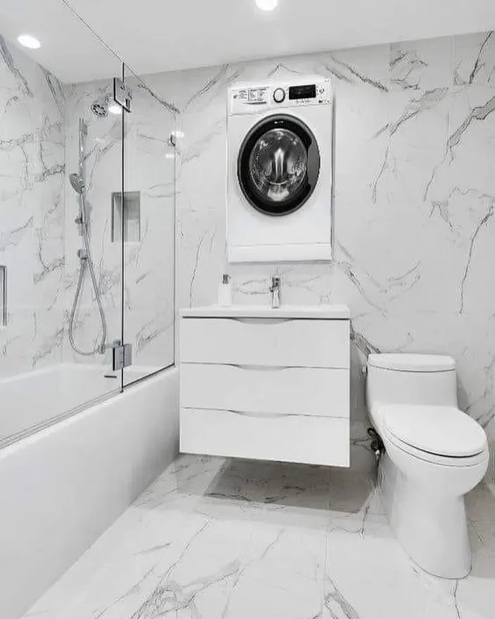 Freestanding soaking tub with marble tile surround